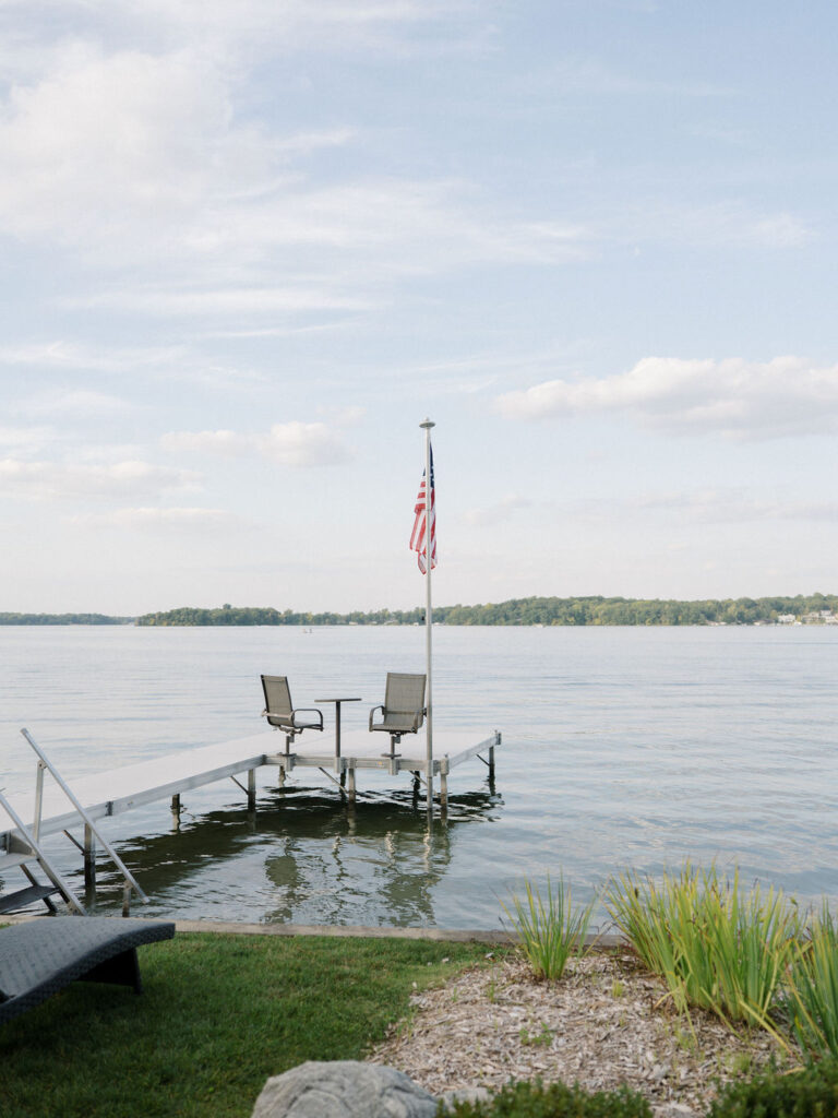 Quiet lake view with dock and chairs during a Bay Pointe Woods wedding weekend.