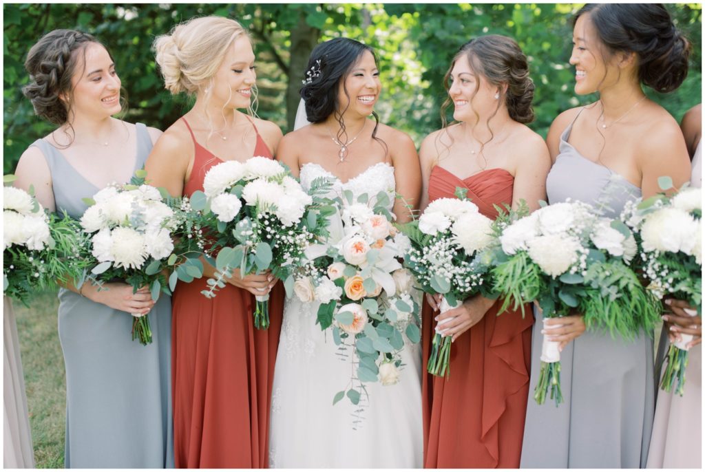 bridesmaids laughing and holding their bouquets at Gable Hill wedding venue, photo by wedding photographer in Grand Rapids, Cynthia Boyle