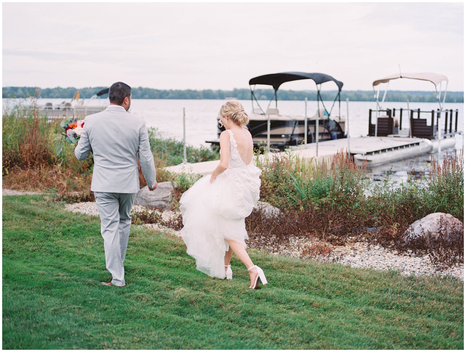 Lauren and Mike walk to the dock to take their bride and groom pictures in Grand Rapids, Michigan Photo by Cynthia Boyle Photography Grand Rapids Wedding Photographer