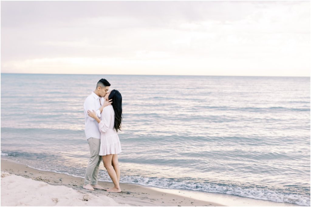 Marie and Justin kiss in front of Lake Michigan at Warren Dunes State Park