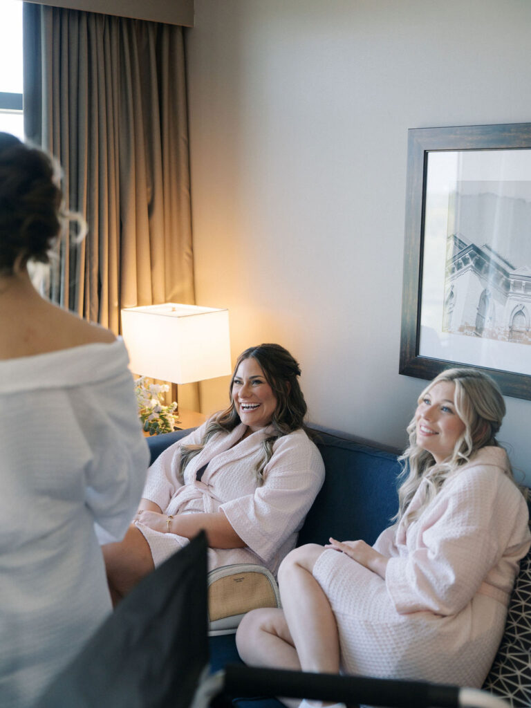 Candid wedding photo of bridesmaids smiling as the bride getting ready for her Notre Dame wedding
