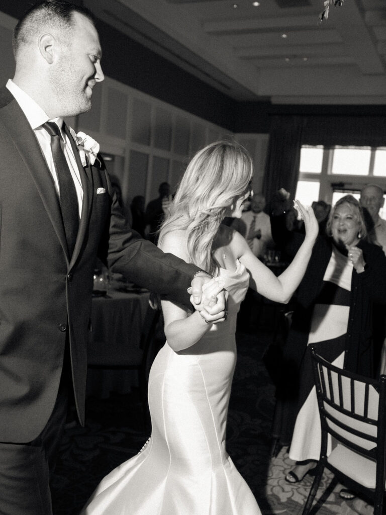 Flash black and white photo of a bride and groom entering their wedding reception