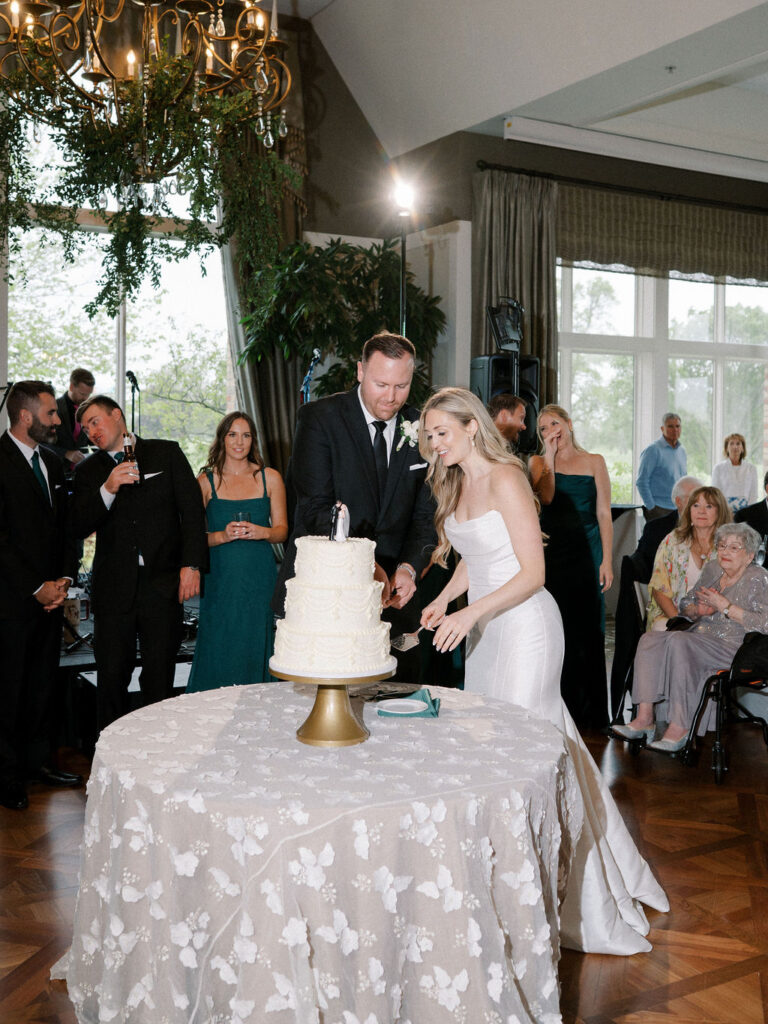 Bride and groom cutting into their wedding cake