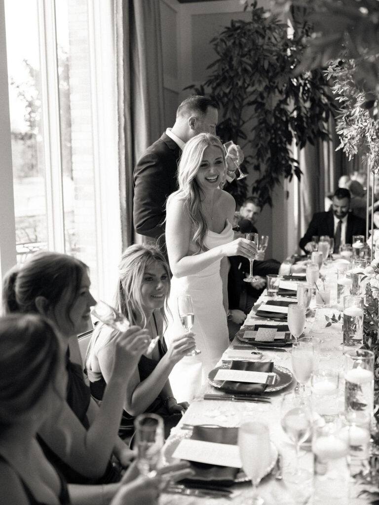 Candid wedding reception photo of a the bride and groom giving speeches