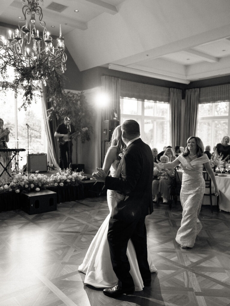 Bride, father, and brides mother dancing during a Cascade Hills Country Club wedding in Grand Rapids, Michigan