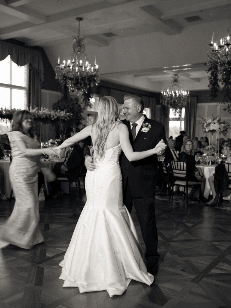 Bride, father, and brides mother dancing during a Cascade Hills Country Club wedding in Grand Rapids, Michigan