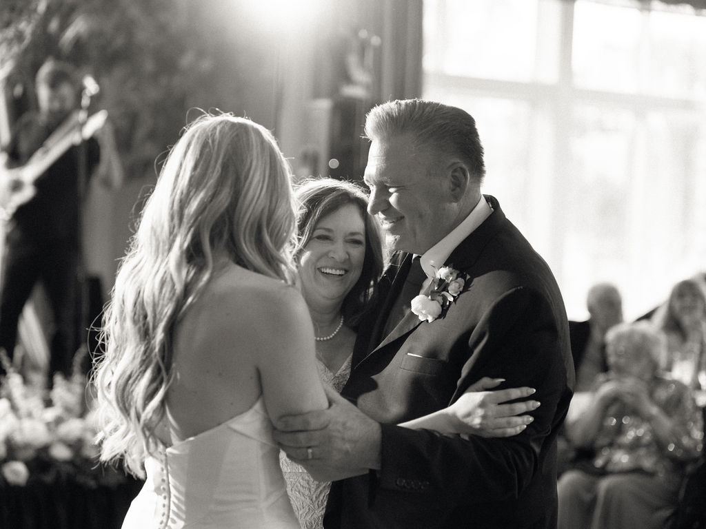 Bride, father, and brides mother dancing during a Cascade Hills Country Club wedding in Grand Rapids, Michigan