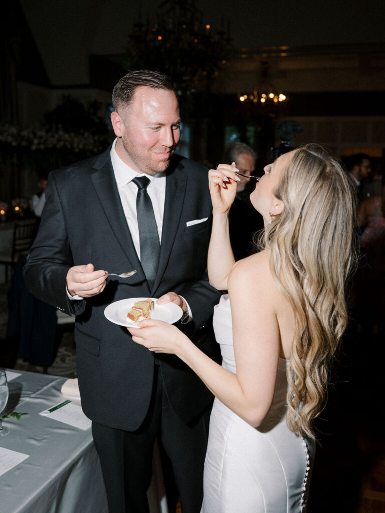 Bride and groom eating cake during their reception