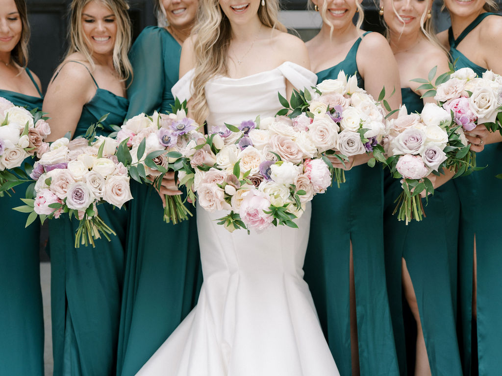 Bride and bridesmaids holding lush pastel bouquets