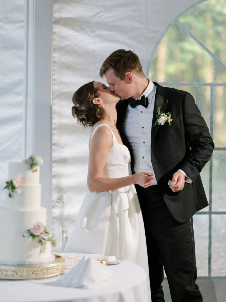 Bride and groom kissing after cake cutting