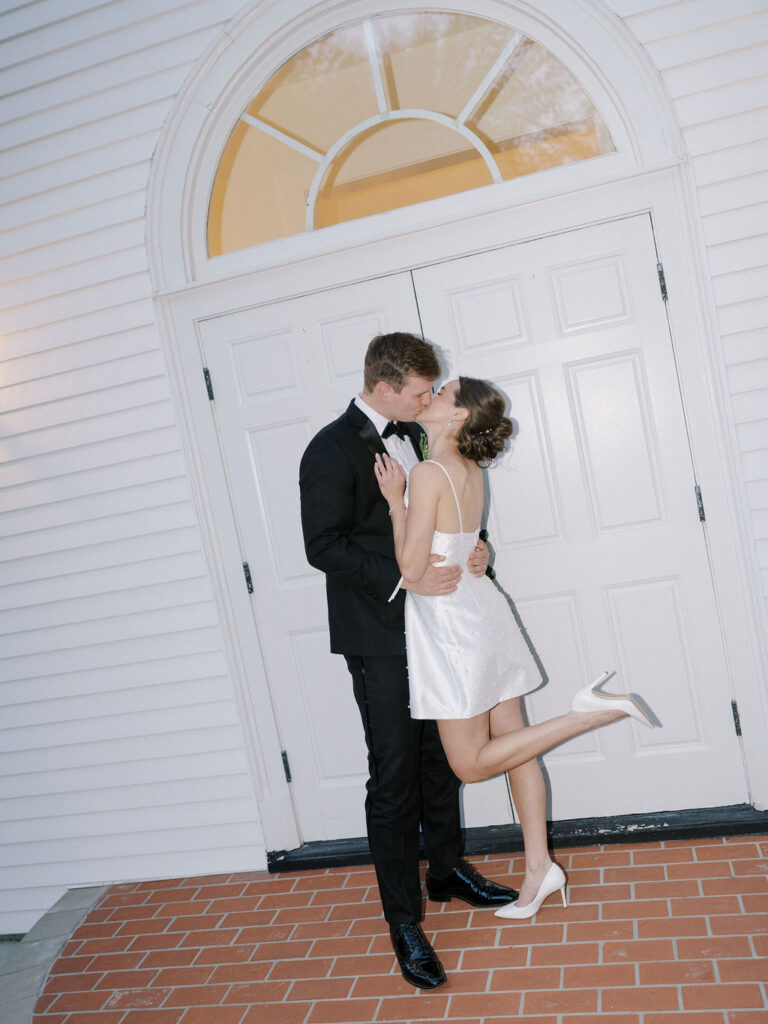Flash wedding reception photo of a the bride and groom kissing