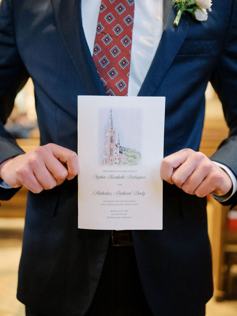 Wedding guest holding the Notre Dame wedding ceremony program