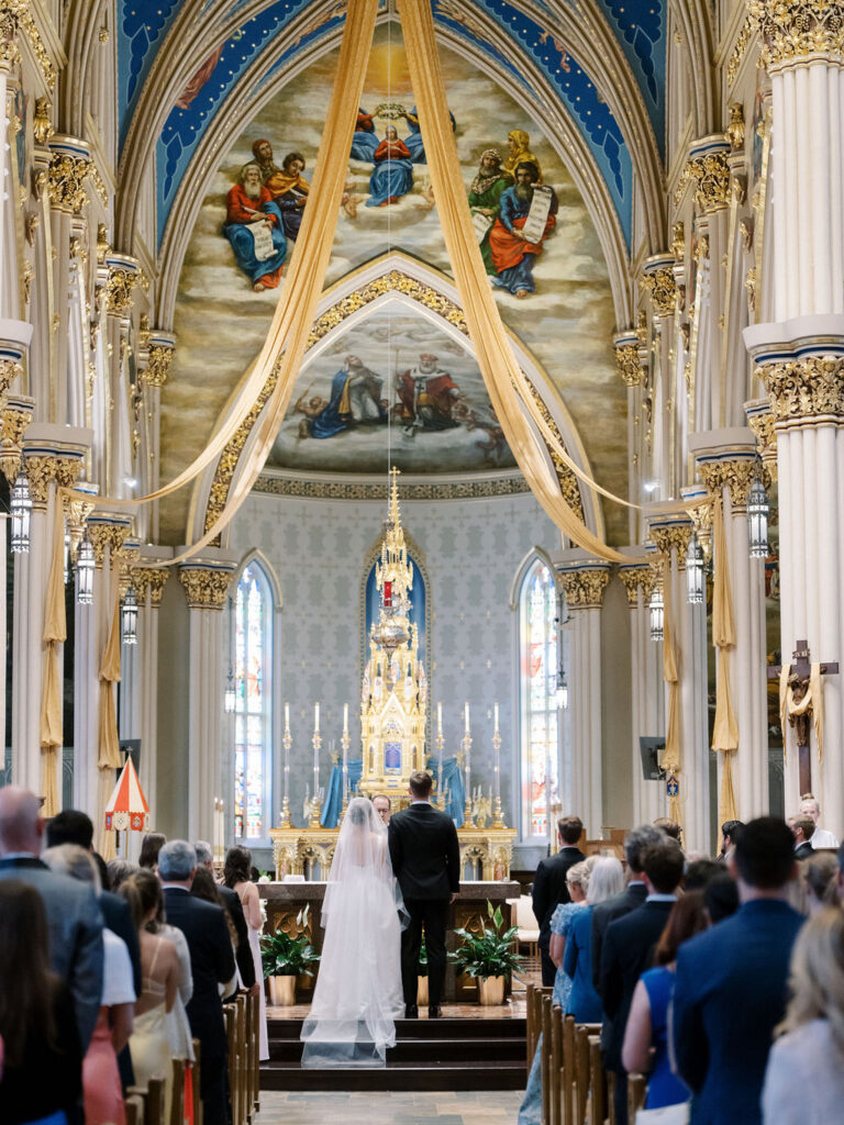 Bride and groom standing at the altar during their Notre Dame Basilica wedding ceremony