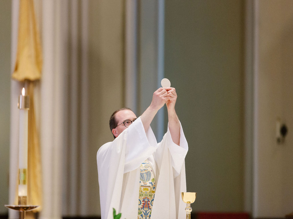 Priest elevates the consecrated host