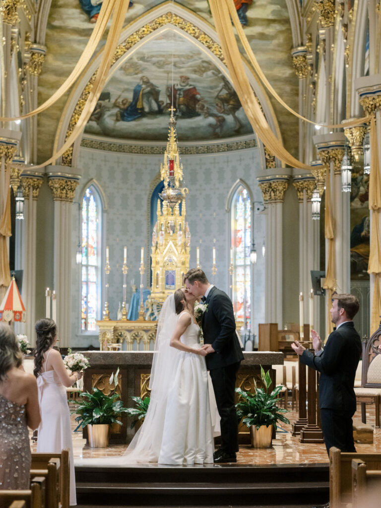 Bride and groom kissing during their Notre Dame Basilica wedding ceremony