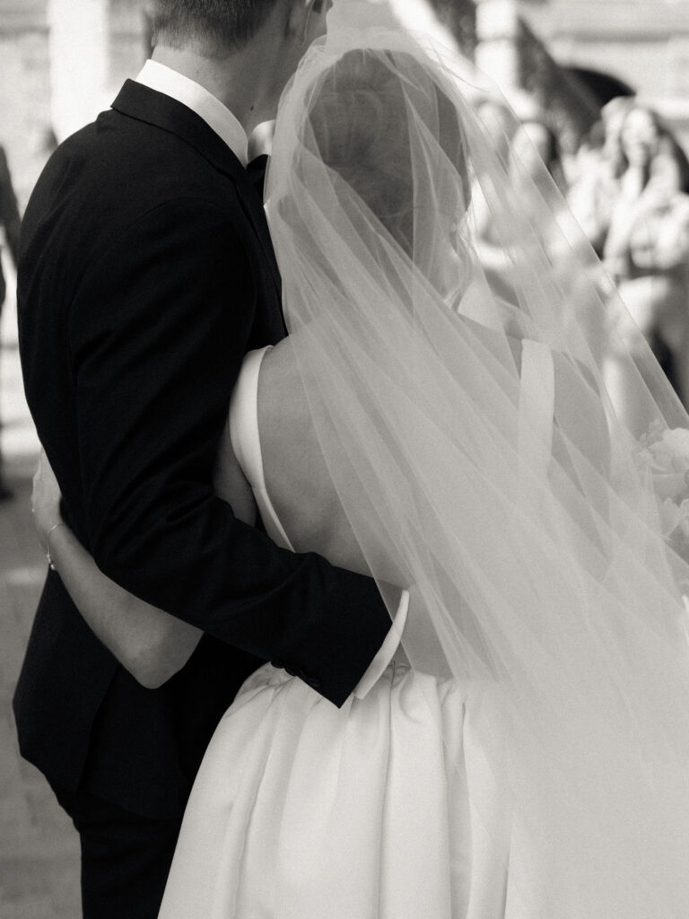 Black and white photo of a bride and groom holding each other