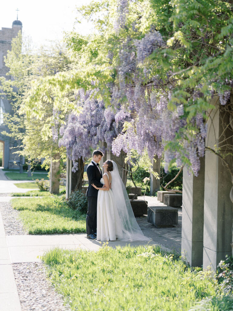 Bride and groom smiling at each other during their outdoor wedding photos at Notre Dame