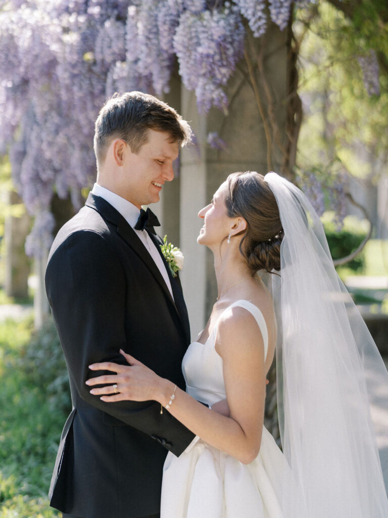 Close up shot of a bride and groom smiling at each other during their outdoor wedding photos at Notre Dame