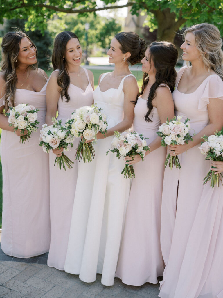 Bride smiling at her bridesmaids during their outdoor photos from a Notre Dame wedding