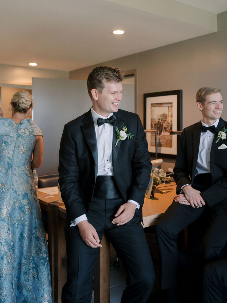 Groom and groomsmen sharing a laugh while getting ready