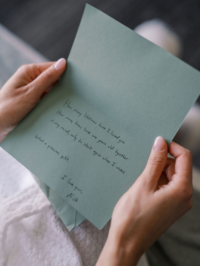 Bride reading a note from the groom as she gets ready