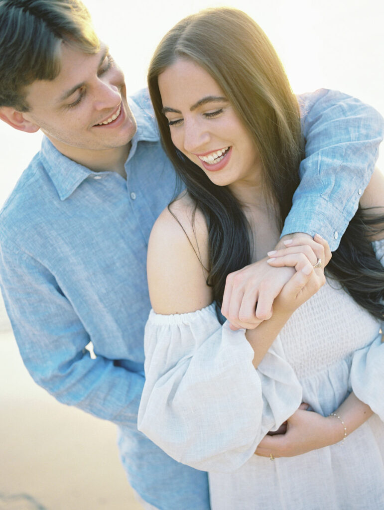 Couple holding each other at sunset during their during their session at Warren Dunes State Park in Michigan