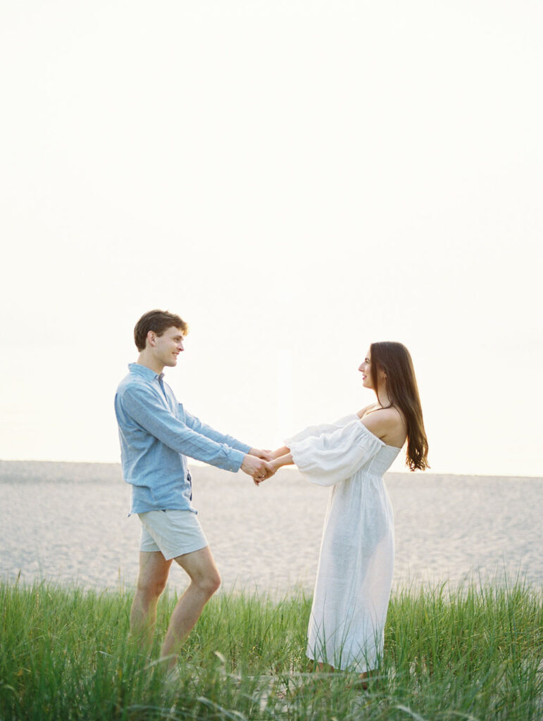 Couple holding hands along the shoreline