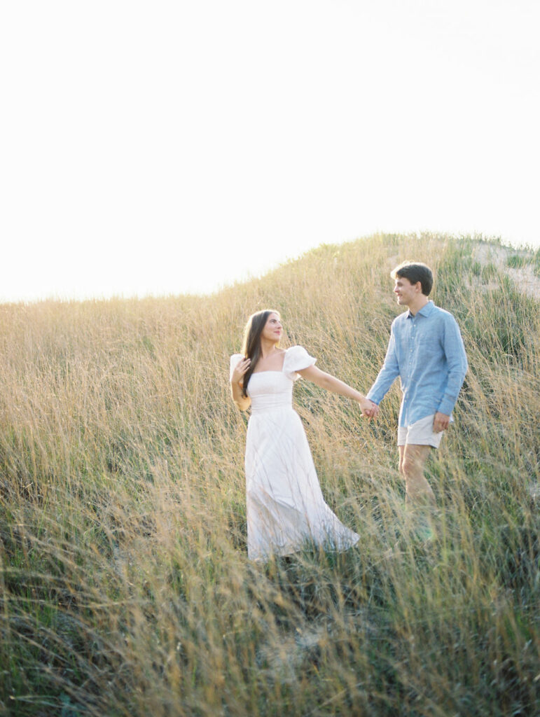 Couple walking through the beach grass for their Warren Dunes State Park engagement photos in Michigan on film