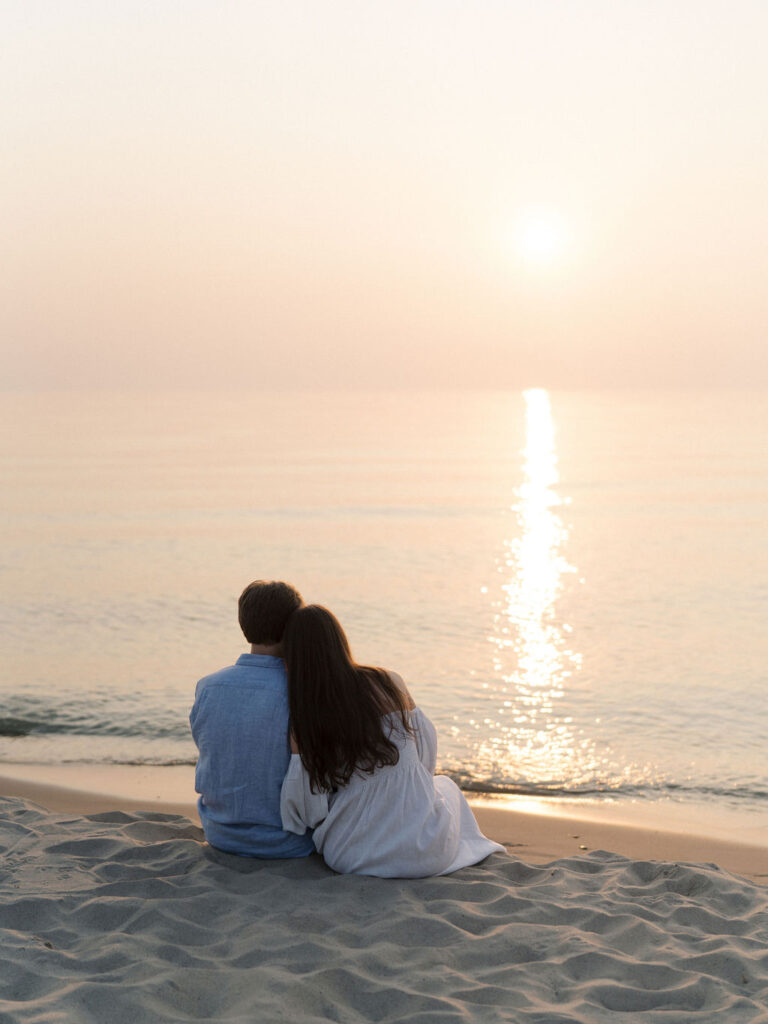 Couple watching the sunset along the shoreline at Warren Dunes State Park in Michigan
