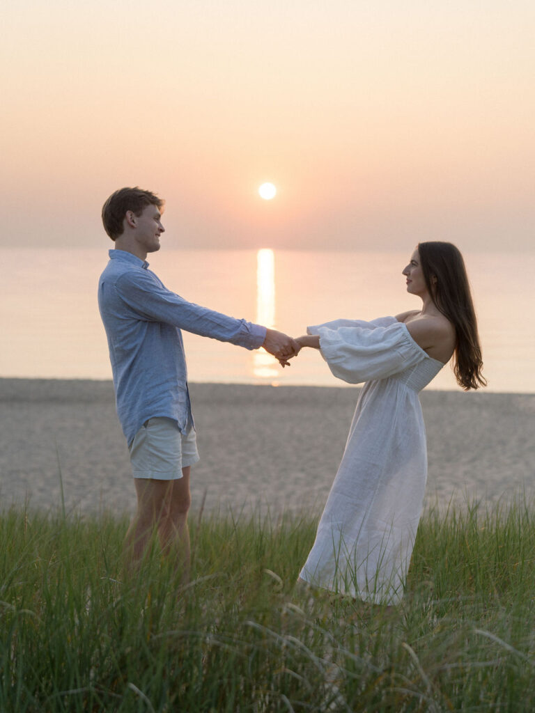 Couples flash engagement photos at sunset at Warren Dunes State Park in Michigan