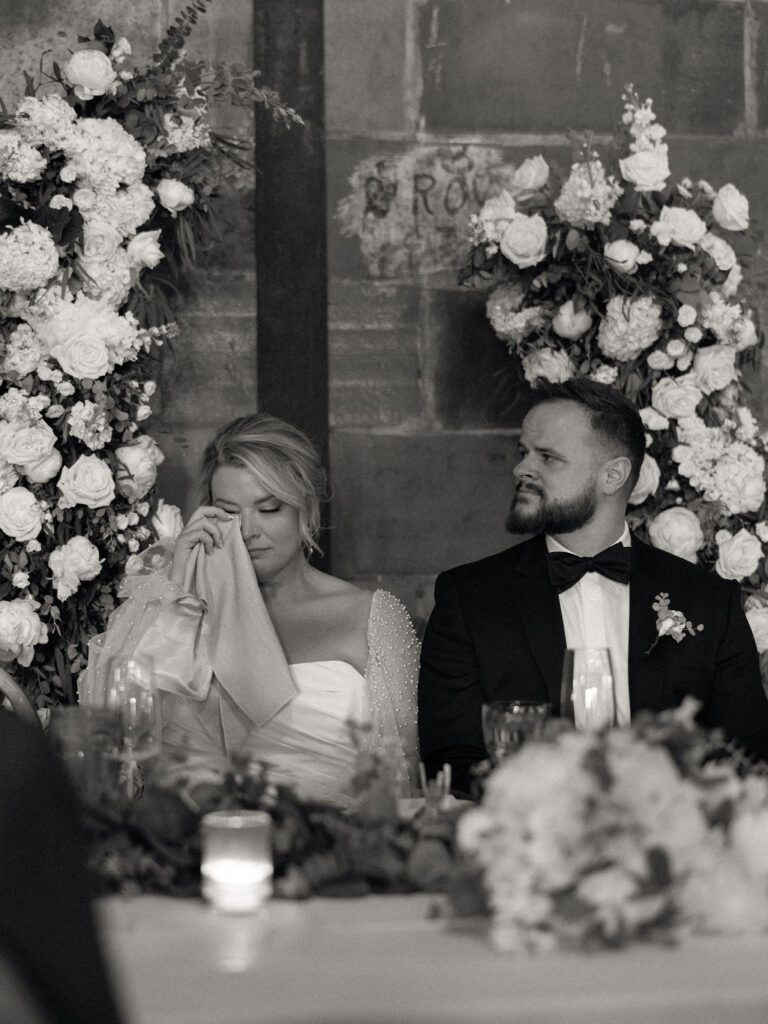 Black and white photo of a bride getting emotional during speeches