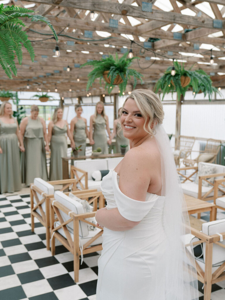 Bride about to share a first look with her bridesmaids in The Greenhouse at The Millhaven