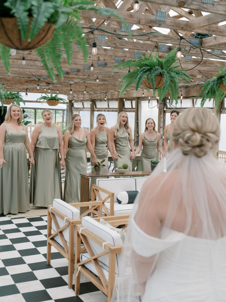 Bride sharing a first look with her bridesmaids in The Greenhouse at The Millhaven