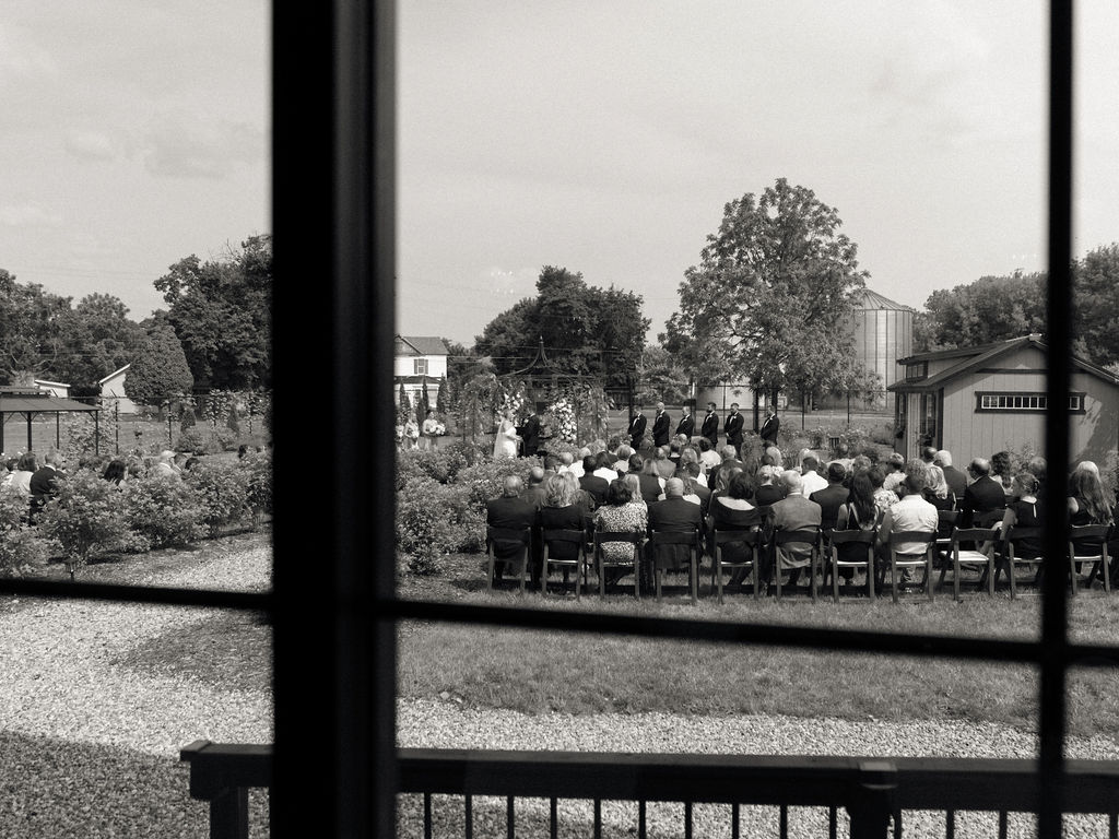 Black and white documentary style photo of an outdoor garden wedding ceremony at The Millhaven