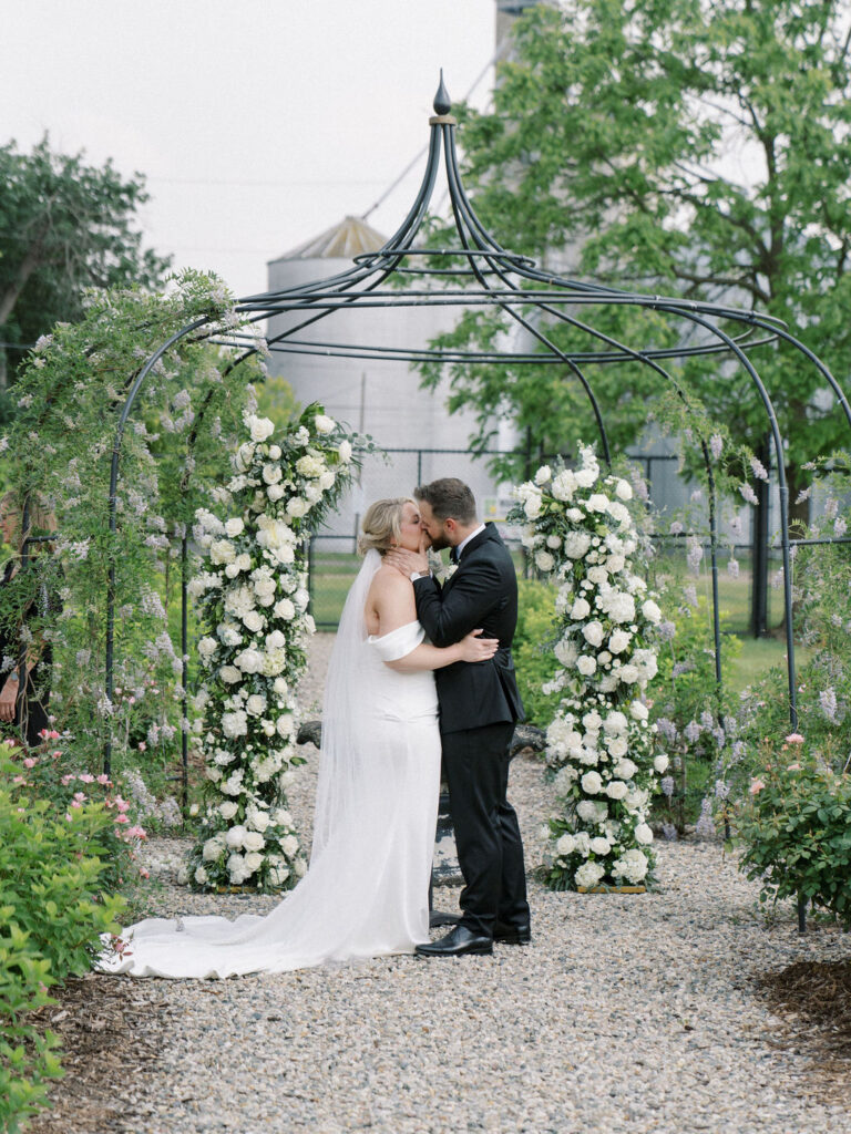 Bride and groom kissing during their outdoor garden wedding ceremony at The Millhaven