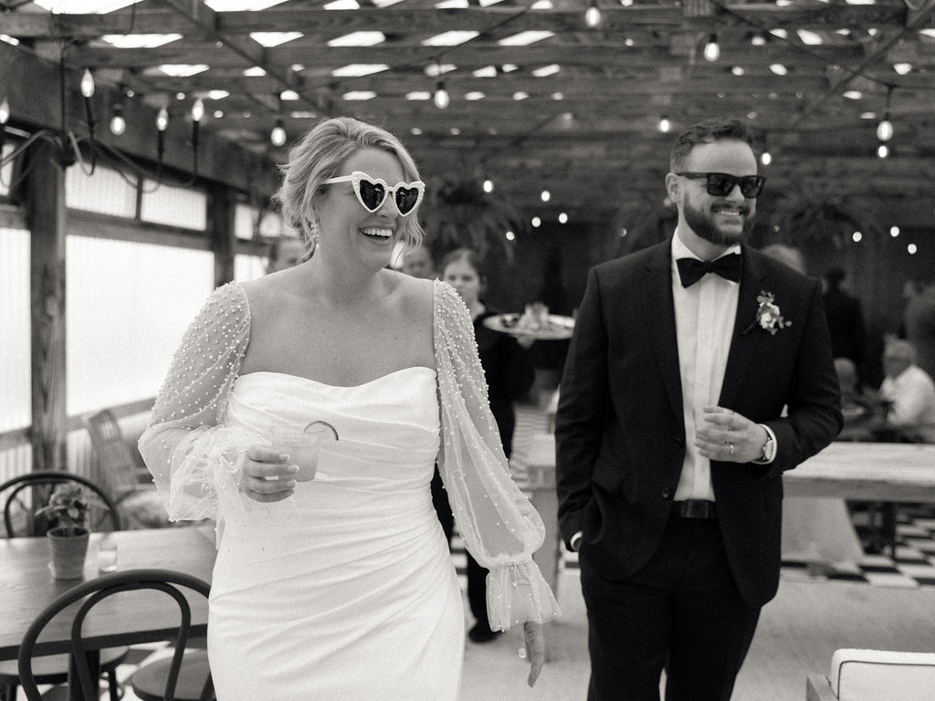 Bride and groom entering cocktail hour with drinks in hand