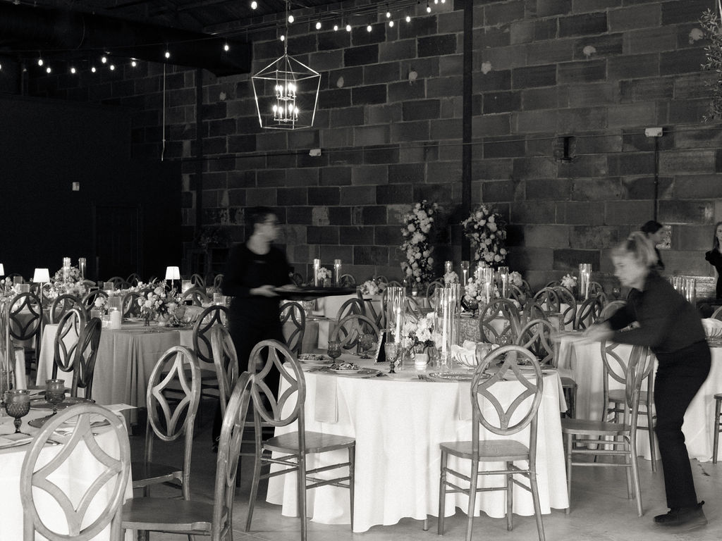 Wedding venue employees getting an indoor wedding reception space ready in The Pickle Factory at The Millhaven 