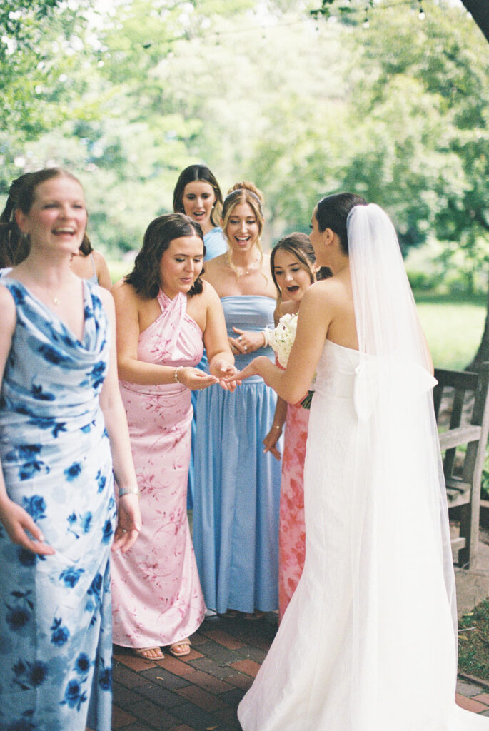 Bridesmaids reacting with joy as bride shows her ring during first look at Saint Mary’s Notre Dame wedding – Cynthia Mae Photo.