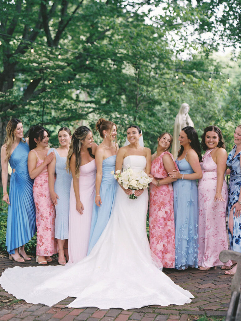 Bride smiling and holding bouquet while bridesmaids cheer around her at Saint Mary’s College – Cynthia Mae Photo.
