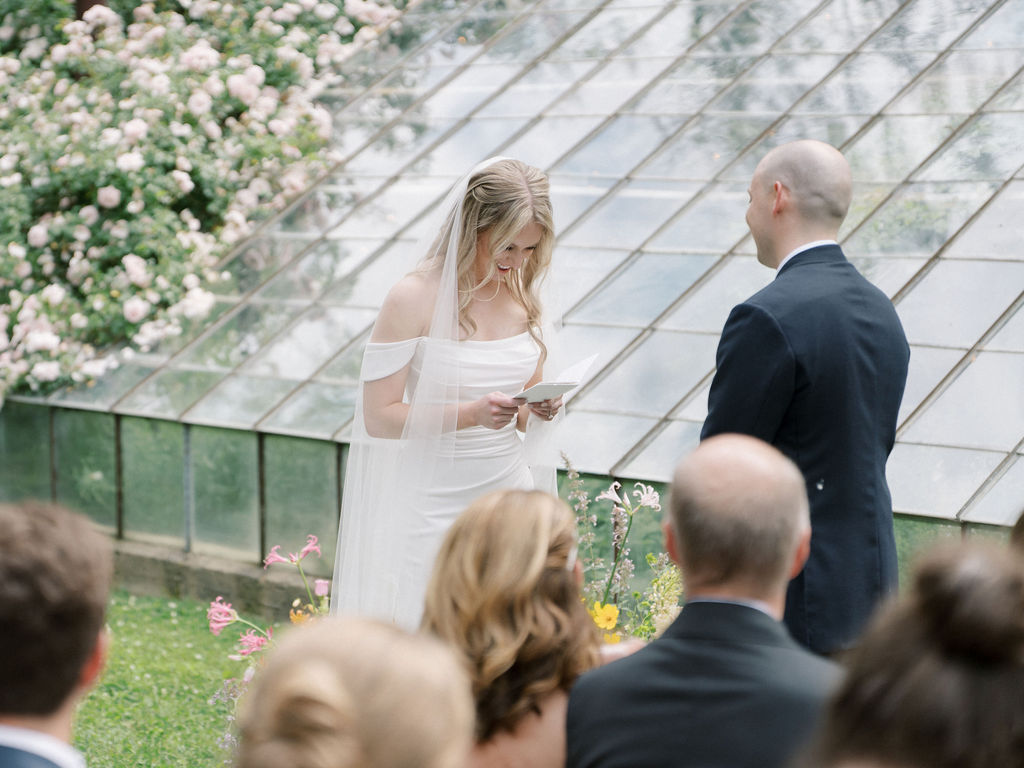 Bride and groom exchanging vows during their outdoor ceremony at The Glass House Community.