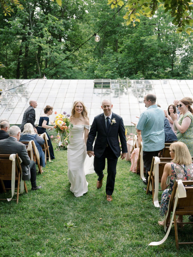 Bride and groom walking back down the aisle as husband and wife after their Glass House Community wedding ceremony
