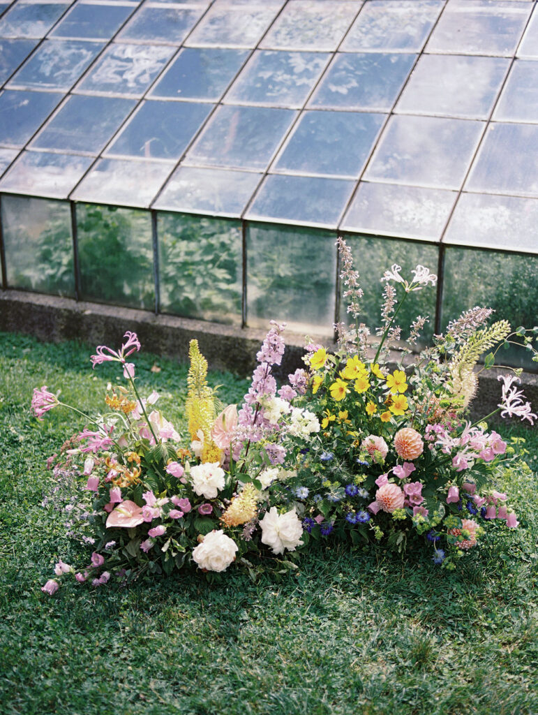 Colorful floral arrangements by Hyssop Floral outside the greenhouse at The Glass House Community.