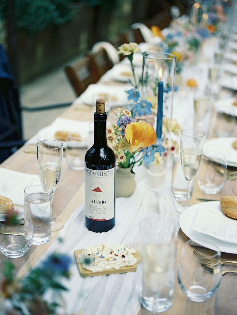 Close-up of wine and florals on the reception table during dinner.