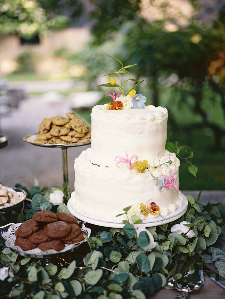 Two-tiered white wedding cake decorated with flowers