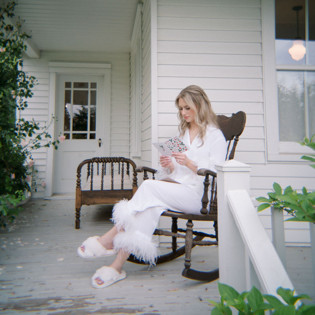 Bride sitting on the porch reading a note before the ceremony.