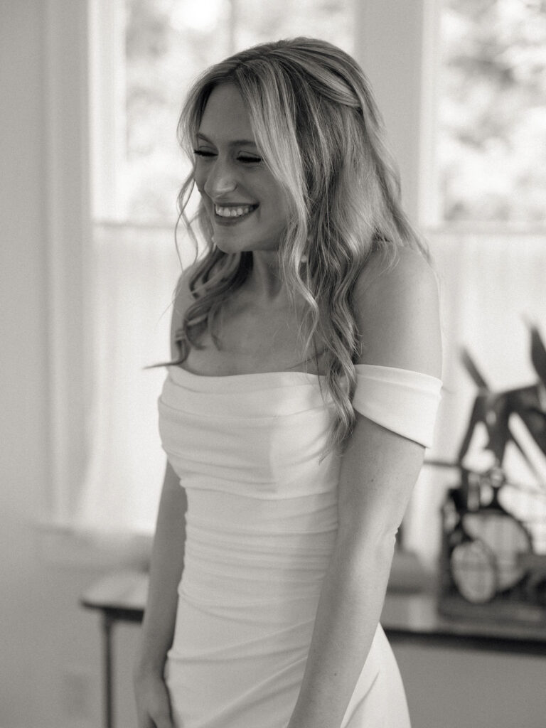 Black and white photo of a bride smiling during her first look with her grandmother
