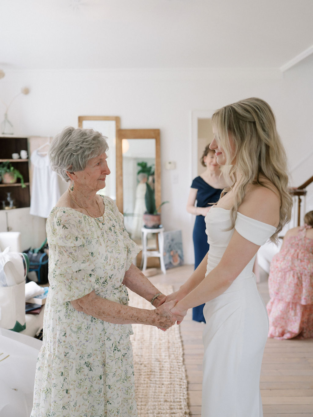 Bride holding hands with her grandmother before walking down the aisle.