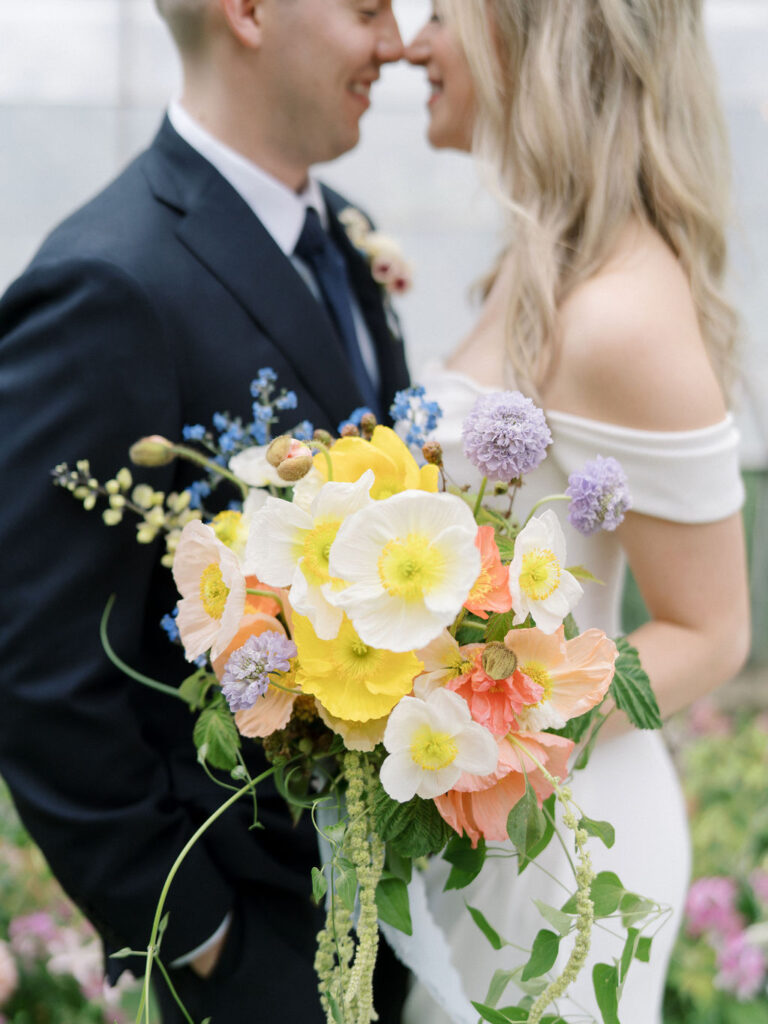 Close up of a bride and groom touching noses during their Glass House Community wedding portraits