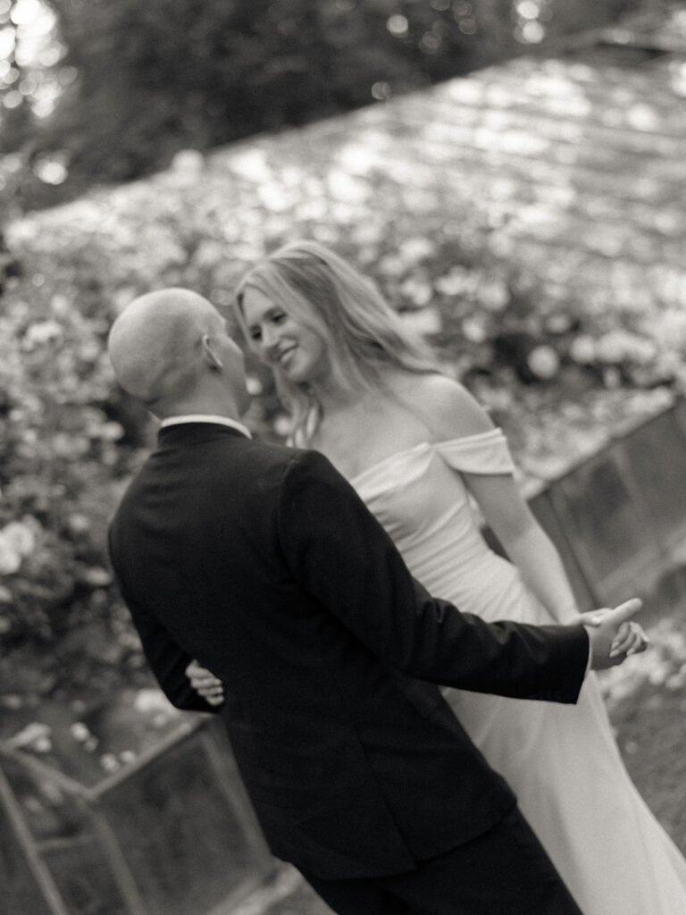 Black and white photo of a bride and groom dancing at Glass House Community wedding venue