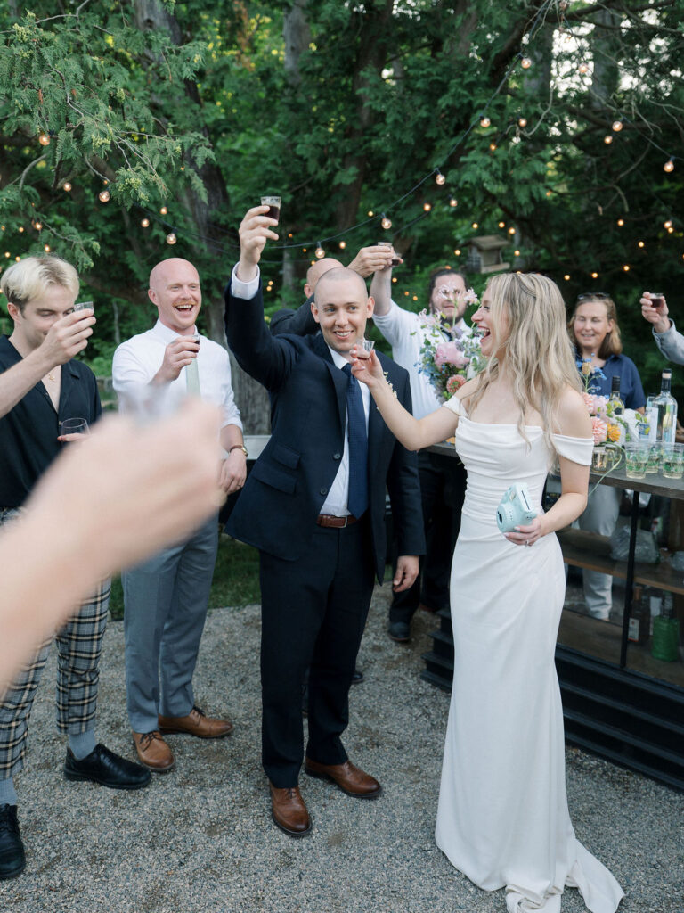 Bride and groom taking shots with guests
